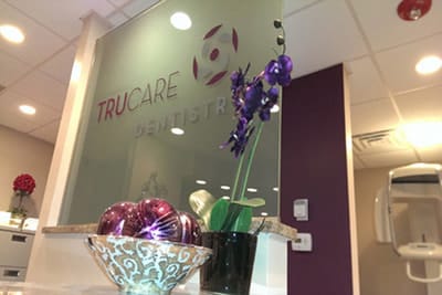 TruCare Dentistry glass signage with a purple orchid in the Bloomingdale office